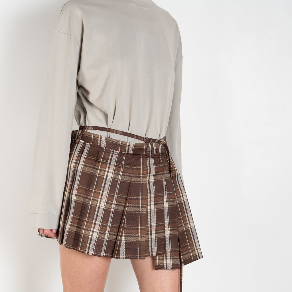 The Pleated Skirt 736 by Acne Studios has a pleated assymetric fit with and adjustable belt above the waist and raw-edge finishes