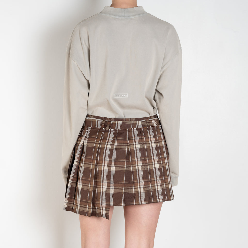 The Pleated Skirt 736 by Acne Studios has a pleated assymetric fit with and adjustable belt above the waist and raw-edge finishes