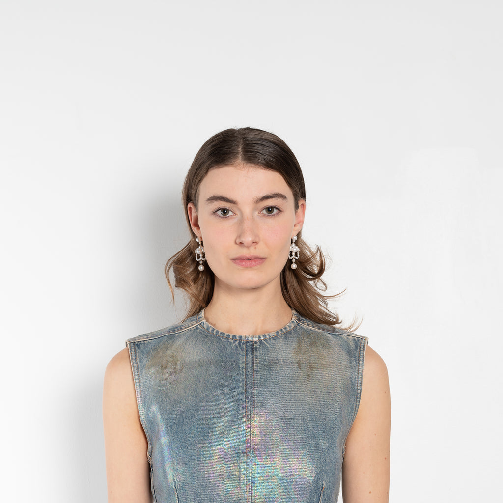 The Coated Denim Dress by Acne Studios is a sleeveless cotton denim twill dress with an iridescent and coated finish