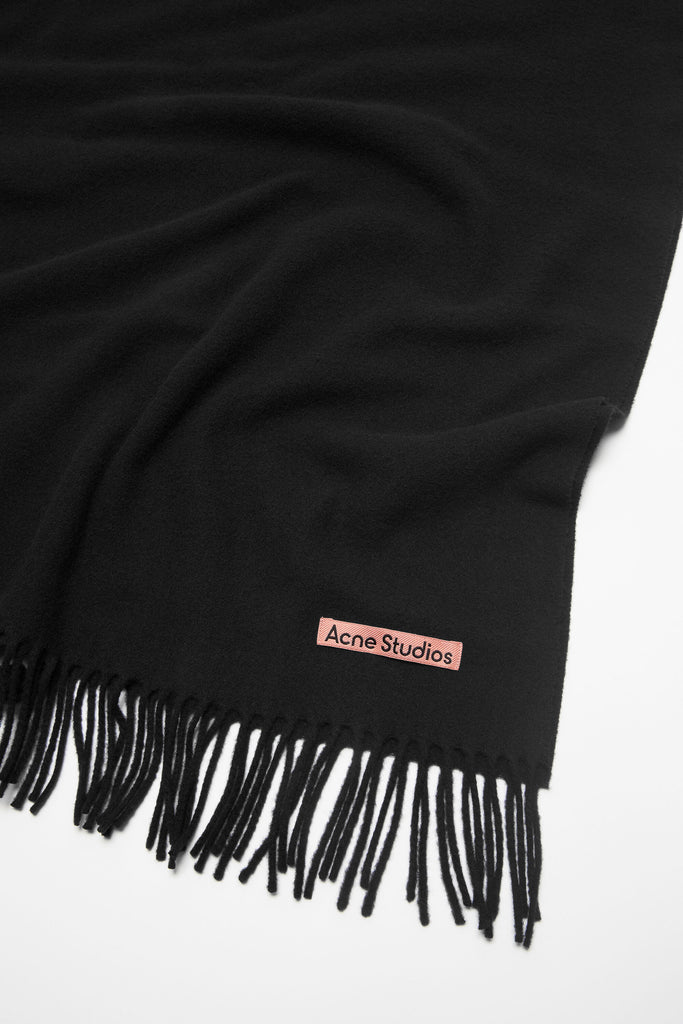 The Oversized Fringed Scarf by Acne Studios is crafted from midweight wool with a soft hand-feel, detailed with a pink Acne Studios label