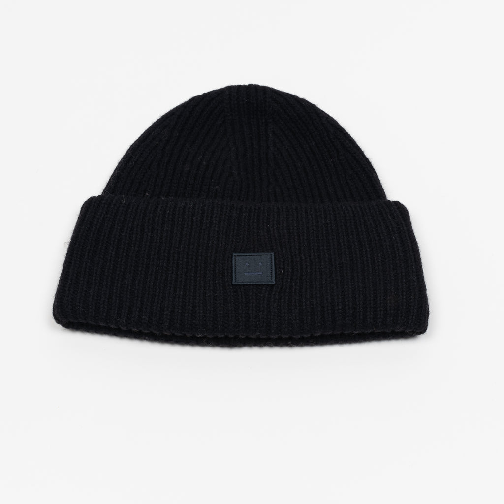 The Small Face Logo Beanie by Acne Studios features a small embroidered face logo patch and ribbed detailing, crafted from chunky wool.