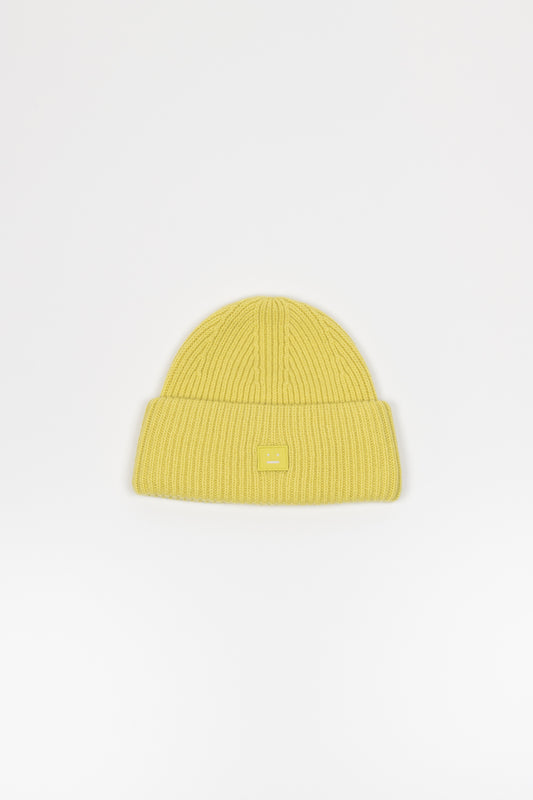 The Small Face Logo Beanie by Acne Studios features a small embroidered face logo patch and ribbed detailing, crafted from chunky wool.