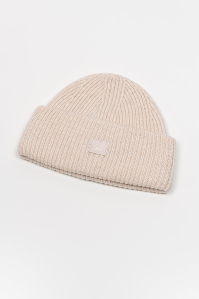 The Small Face Logo Beanie by Acne Studios features a small embroidered face logo patch and ribbed detailing, crafted from chunky wool.