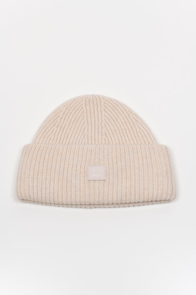 The Small Face Logo Beanie by Acne Studios features a small embroidered face logo patch and ribbed detailing, crafted from chunky wool.