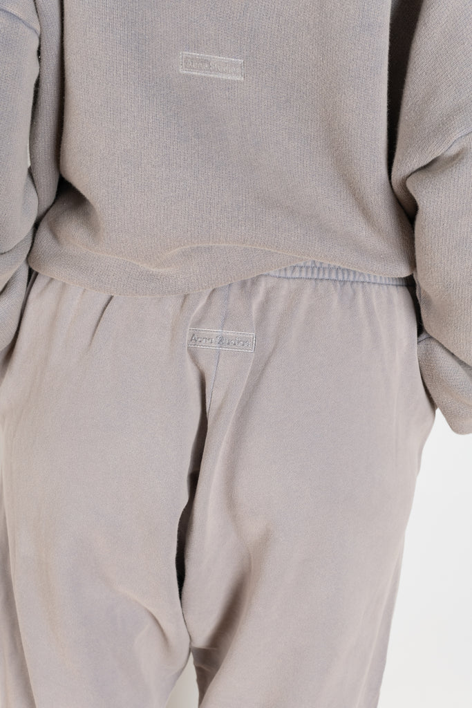 The Jogging 0015 by Acne Studios are mid waist joggers with an elastic waistband and a small rubber logo patch on the back center