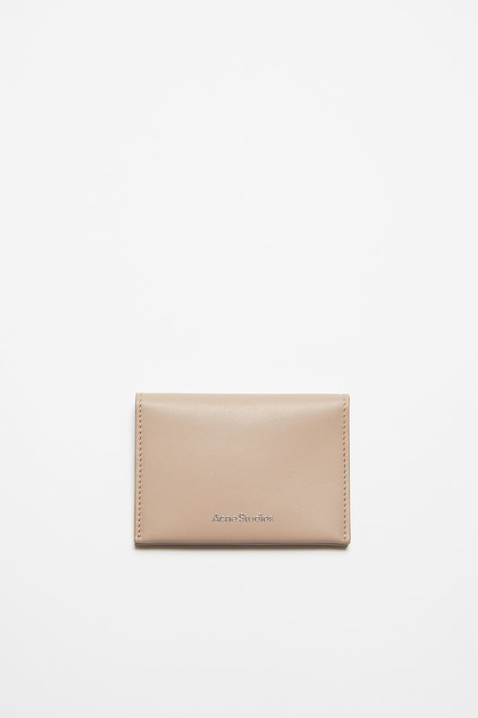 The Folded Leather Wallet by Acne Studios features a folded opening with card slot compartments, crafted from smooth leather and detailed with an Acne Studios logo on the front
