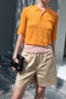 The Gauze Polo by Auralee is a cropped polo top in a vibrant orange sheer cotton jersey