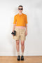 The Gauze Polo by Auralee is a cropped polo top in a vibrant orange sheer cotton jersey