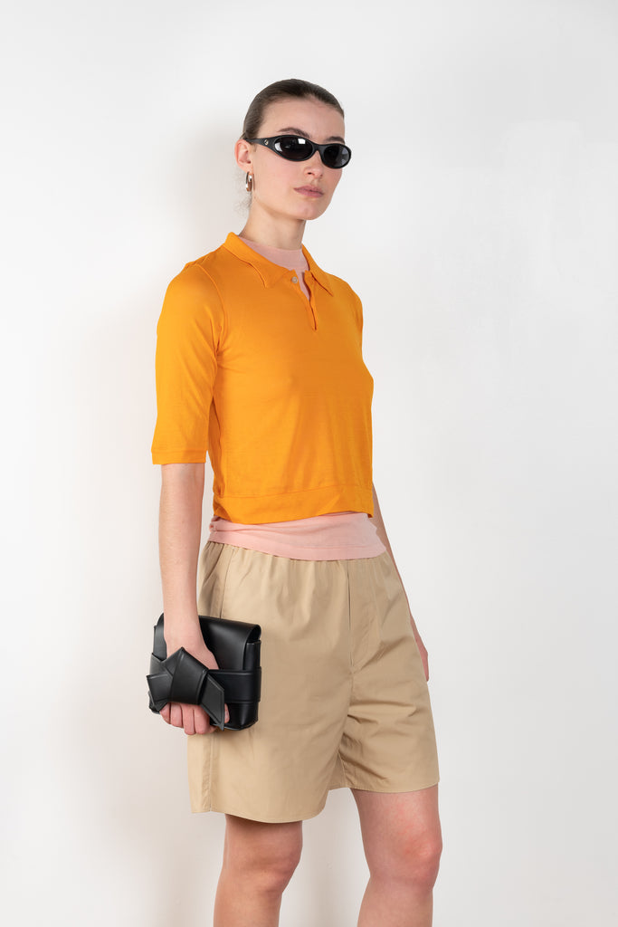 The Gauze Polo by Auralee is a cropped polo top in a vibrant orange sheer cotton jersey