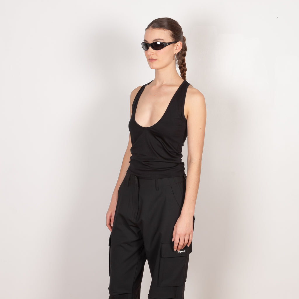 The Deep Cut Tank Top by Coperni is a fitted tank top with a deep cut at the front