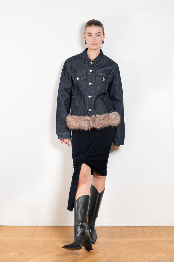 The Faux Fur Hem Denim Jacket by Coperni is a denim jacket with a faux fur waistband at the front