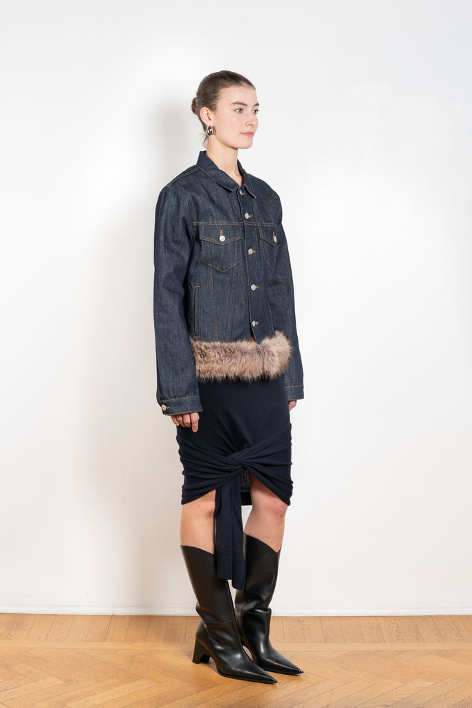 The Faux Fur Hem Denim Jacket by Coperni is a denim jacket with a faux fur waistband at the front