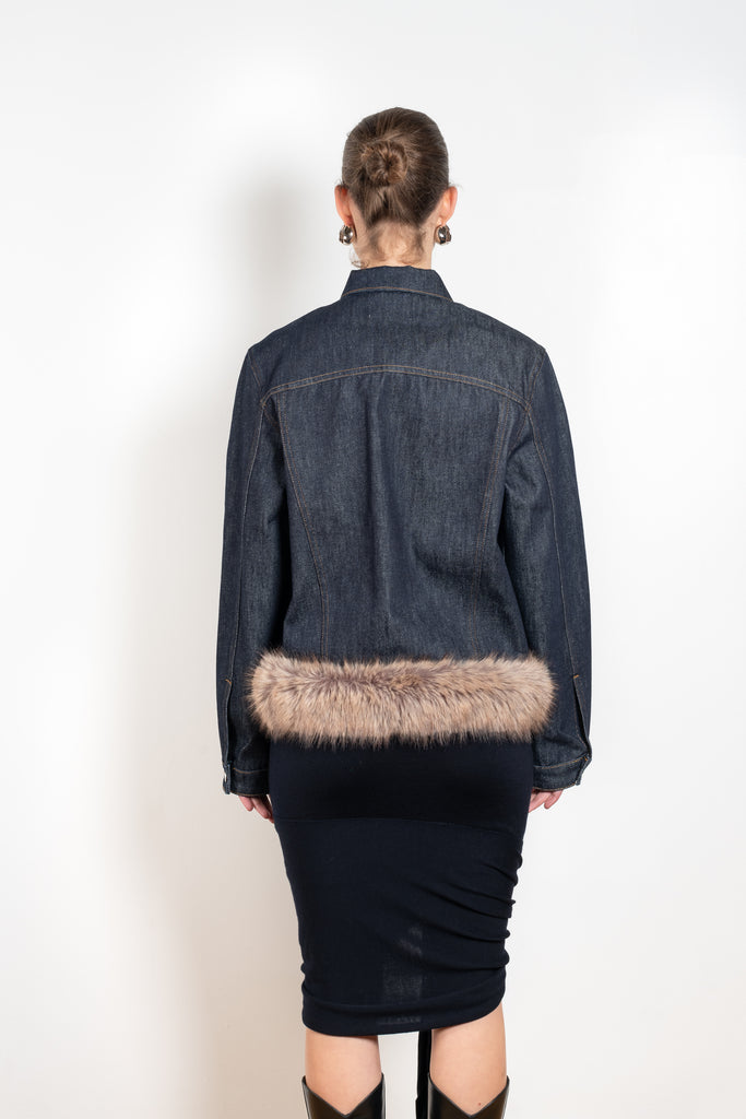 The Faux Fur Hem Denim Jacket by Coperni is a denim jacket with a faux fur waistband at the front