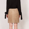 The Suede Skirt by Coperni is a beige suede leather skirt with a contrasted black patent detail