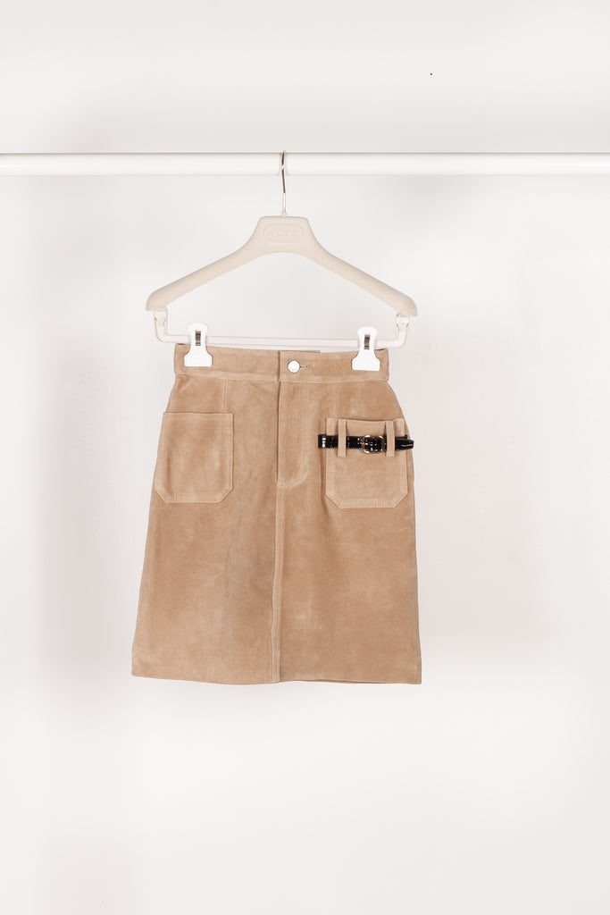 The Suede Skirt by Coperni is a beige suede leather skirt with a contrasted black patent detail