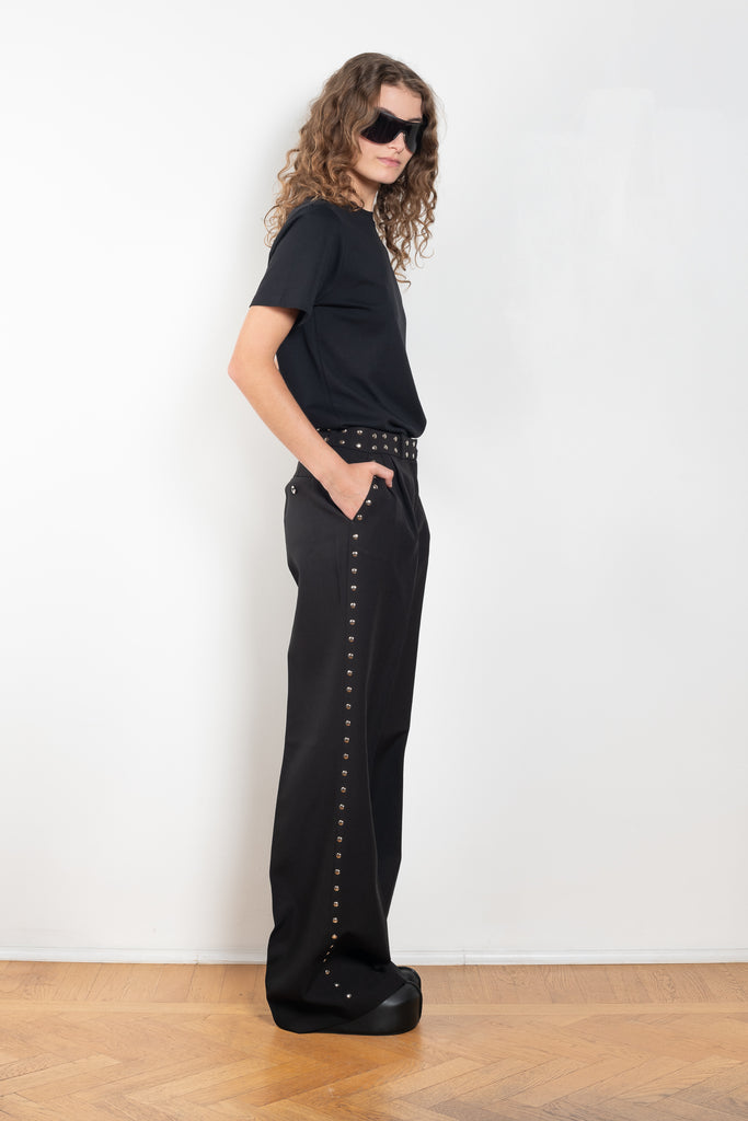 The Studded Tailored Trouser by Coperni is a mid rise trouser with a long wide leg and allover studs on the side and waistline