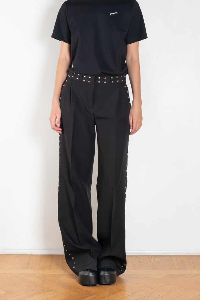 The Studded Tailored Trouser by Coperni is a mid rise trouser with a long wide leg and allover studs on the side and waistline