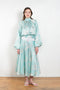 The Tracy Silk Blouse by Julie Kegels is a silk wrap top in aqua with a Hawaïan floral print and contrasting cuffs