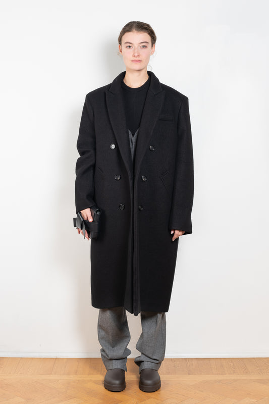 The Double Breasted Coat by KASSL Editions is a long coat crafted from boiled wool with classic men coat inspired detailing