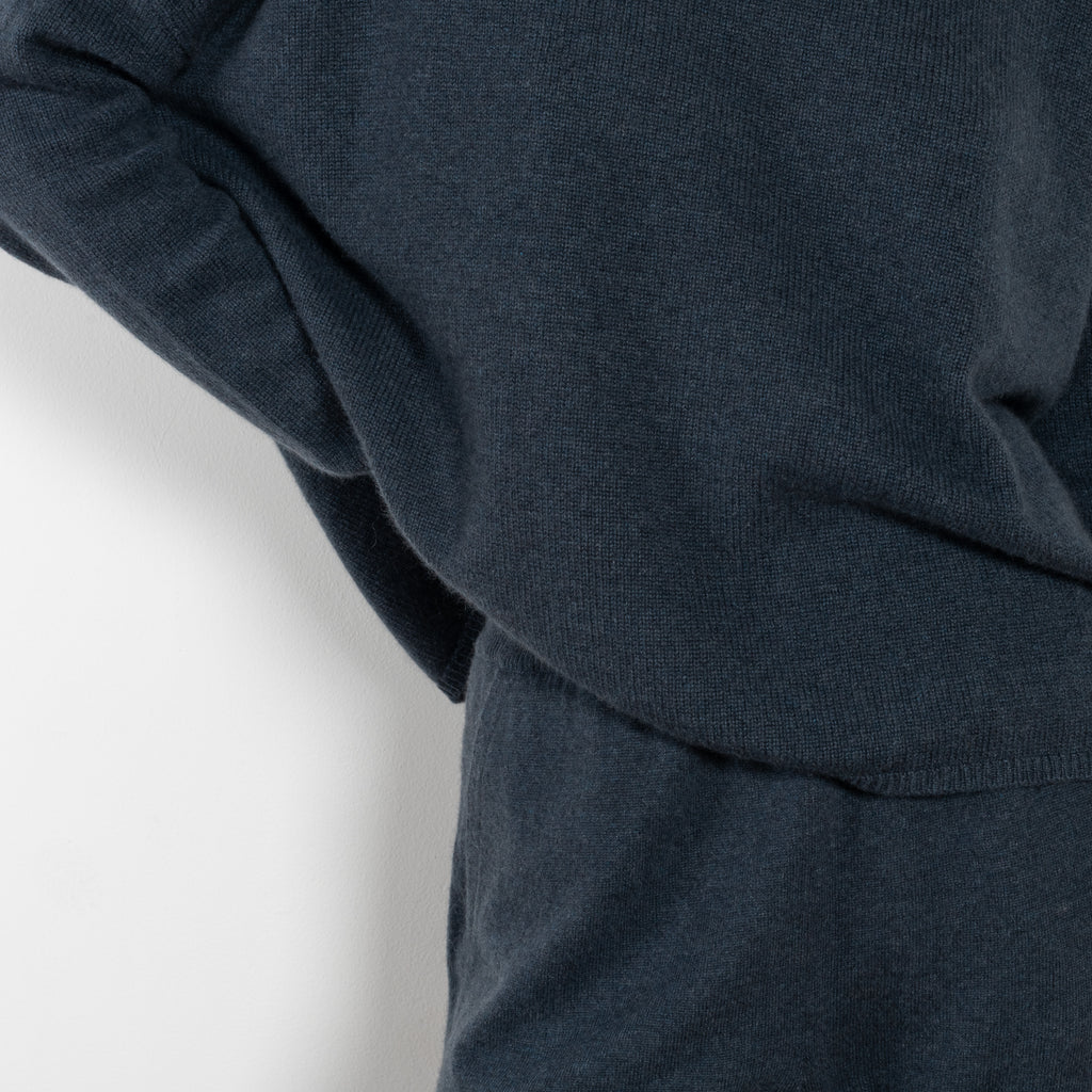 The Sandy Sweater by LISA YANG has a straight fit with dropped shoulders and a raw hem mock neck