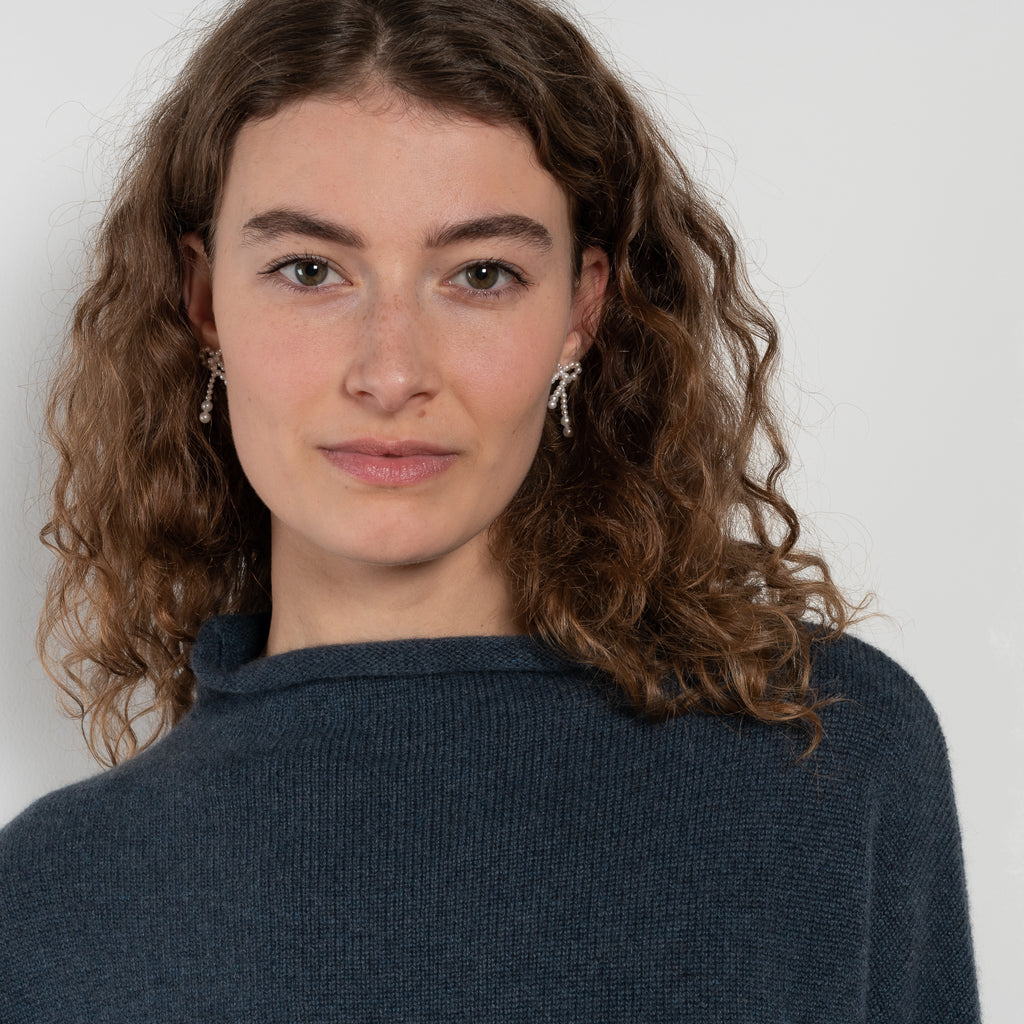 The Sandy Sweater by LISA YANG has a straight fit with dropped shoulders and a raw hem mock neck