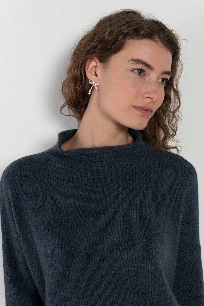 The Sandy Sweater by LISA YANG has a straight fit with dropped shoulders and a raw hem mock neck