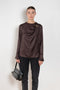 The Azae Blouse by Loulou Studio is a refined silk twill blouse with a draped detail and hardware embellishment