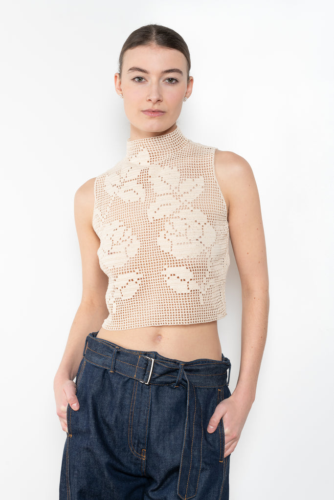 The Crochet Lace Top by Magda Butrym is a cropped top with a high neck and an all-over floral design in traditional Polish crochet technique