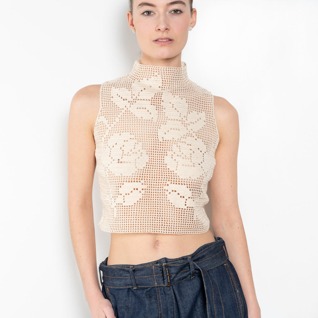 The Crochet Lace Top by Magda Butrym is a cropped top with a high neck and an all-over floral design in traditional Polish crochet technique