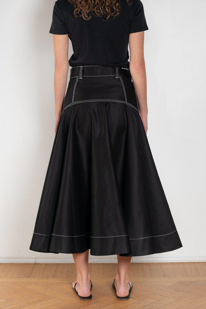 The Flared Workwear Skirt by Meryll Rogge is a long cotton skirt with a flat front and flared fit on the back