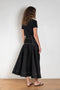 The Flared Workwear Skirt by Meryll Rogge is a long cotton skirt with a flat front and flared fit on the back