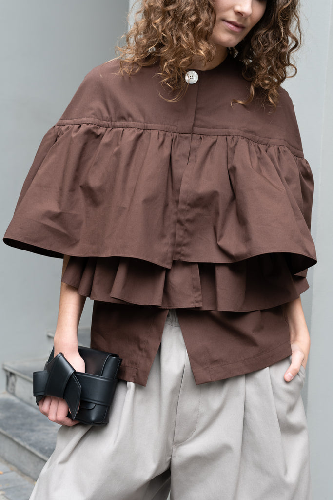 The Ruffle Tiered Top by Meryll Rogge is a crisp cotton top with layered ruffles that can be tucked into your trousers