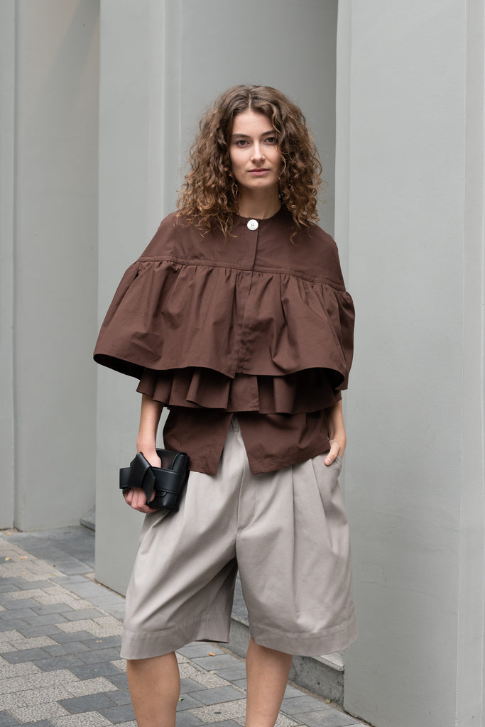 The Ruffle Tiered Top by Meryll Rogge is a crisp cotton top with layered ruffles that can be tucked into your trousers