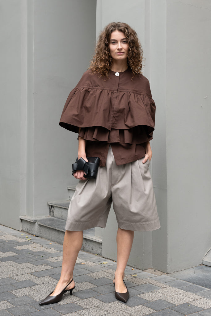 The Ruffle Tiered Top by Meryll Rogge is a crisp cotton top with layered ruffles that can be tucked into your trousers