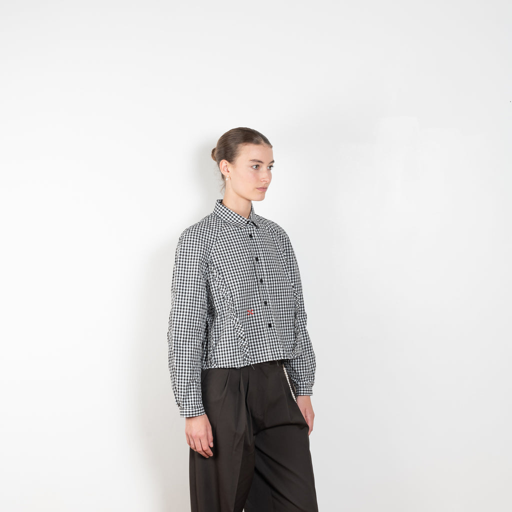 The Moshi Moshi Top by Nackiye is a buttoned up tailored shirt with front and back ruffles