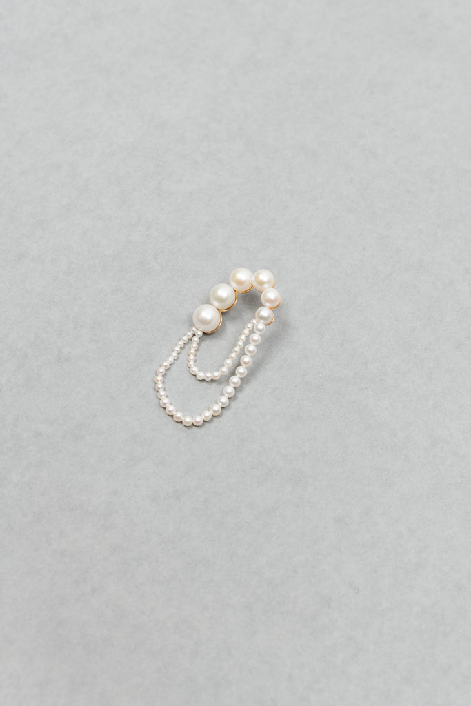 The motif of Bille Brahe's iconic Peggy wrapped to nest around one's ear appears on the Embrassée de Perle Earring, designed as a graduation of freshwater pearls