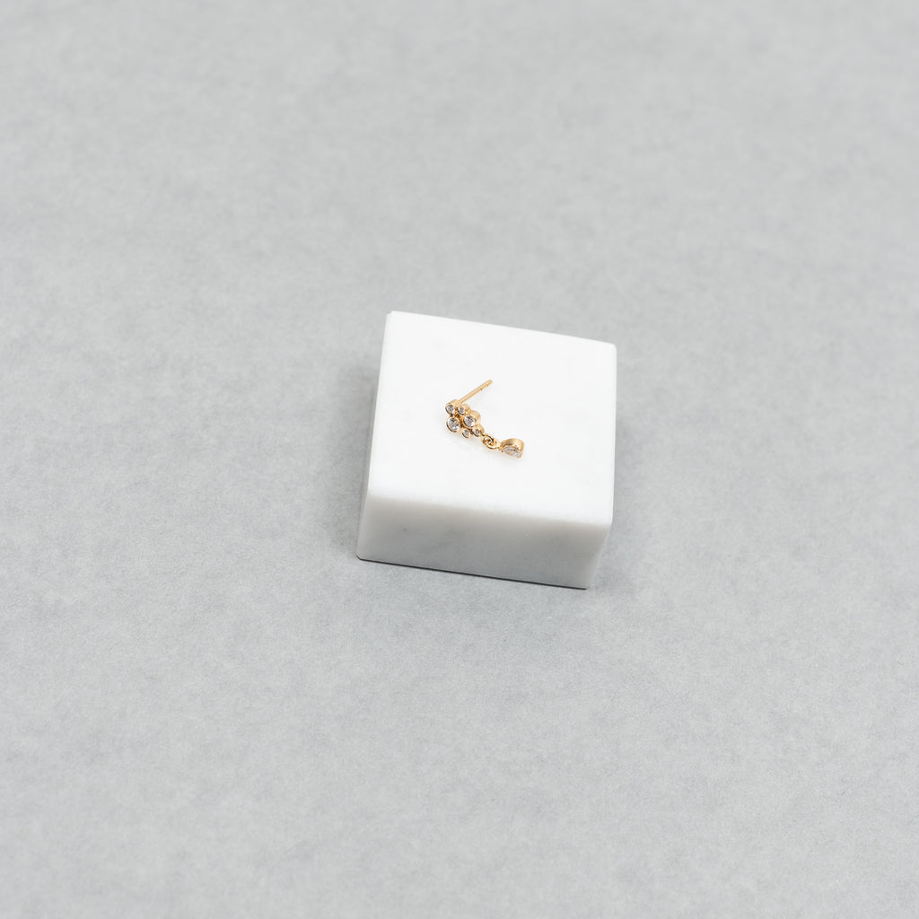 The Petite Splash Earring by Sophie Bille Brahe is a delicate and dainty earring designed to emulate the splashing of water with diamonds varying in size and a pear shaped diamond drop