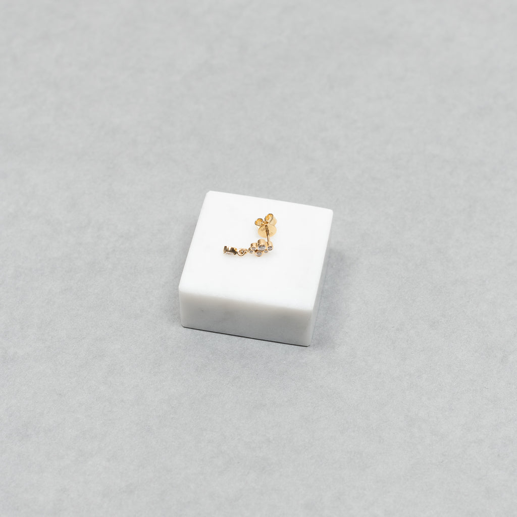 The Petite Splash Earring by Sophie Bille Brahe is a delicate and dainty earring designed to emulate the splashing of water with diamonds varying in size and a pear shaped diamond drop