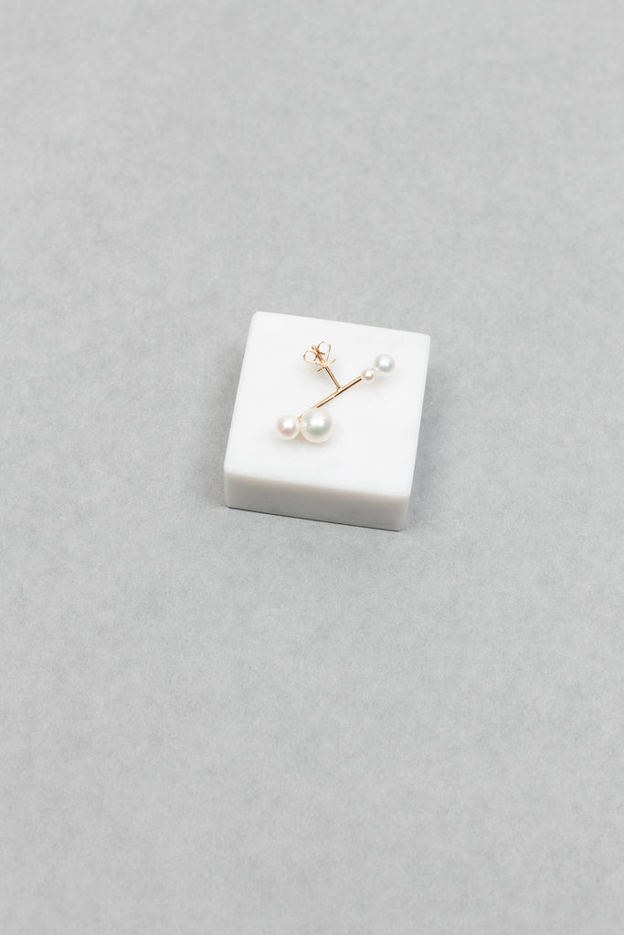 The Stellari Right by Sophie Bille Brahe is a petite version of the Stellari Perle earring with pearls in various sizes placed on a curved gold stem