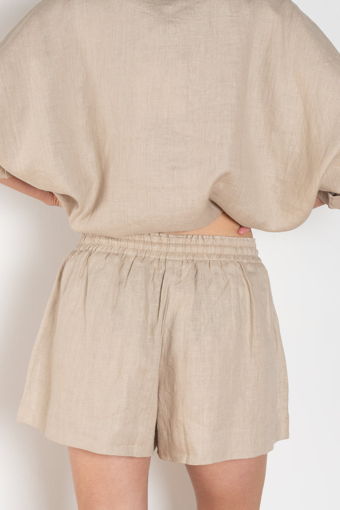 The Shkip Shorts Linen by Suzie Kondi is an A-line shorts with an elastic waistband and roomy pockets. An easy, pull-on style.