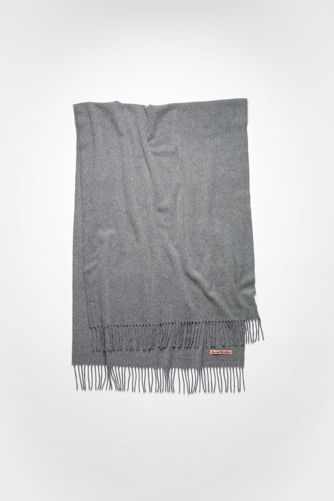 The Fringe Wool Scarf 217 by Acne Studios is a signature fringed scarf with a pink Acne Studios label crafted from midweight wool in dark grey melange