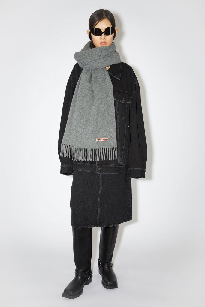 The Fringe Wool Scarf 217 by Acne Studios is a signature fringed scarf with a pink Acne Studios label crafted from midweight wool in dark grey melange