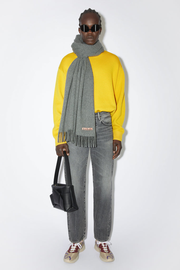 The Fringe Wool Scarf 217 by Acne Studios is a signature fringed scarf with a pink Acne Studios label crafted from midweight wool in dark grey melange