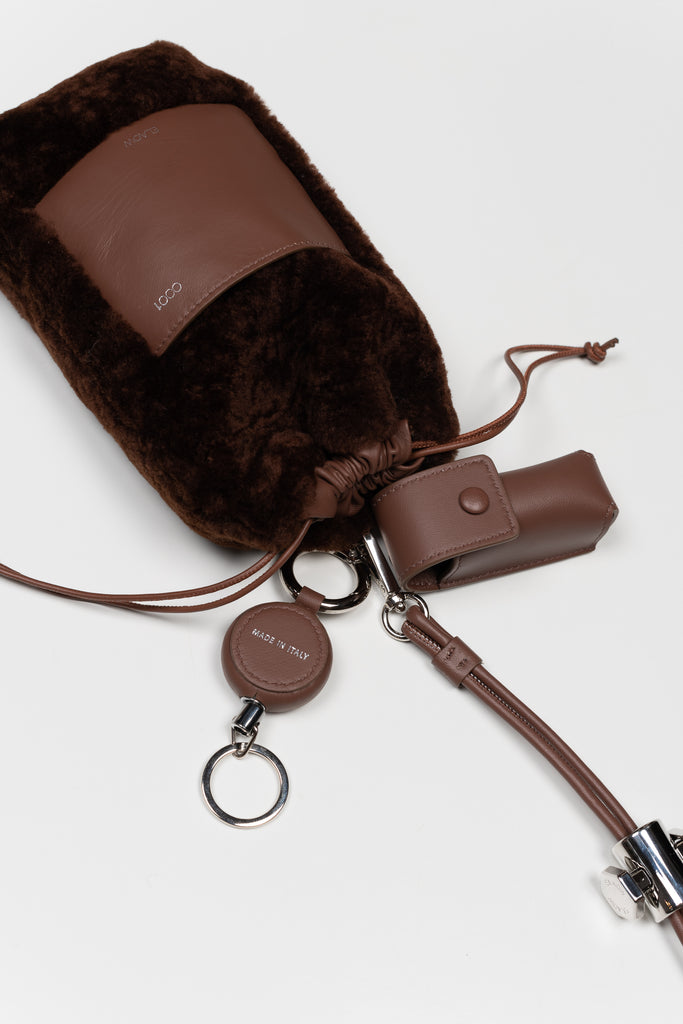 The PXL1JW Shearling Bag by ELAOW is a micro shearling bag to contain your phone, headphones, coins and cards in soft nappa leather with a  jewel strap 