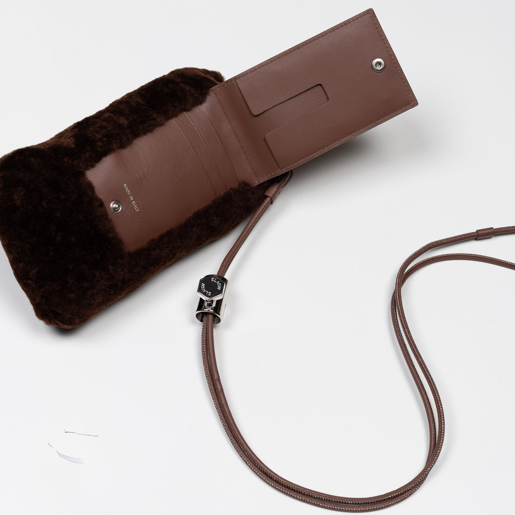 The PXL1JW Shearling Bag by ELAOW is a micro shearling bag to contain your phone, headphones, coins and cards in soft nappa leather with a  jewel strap 