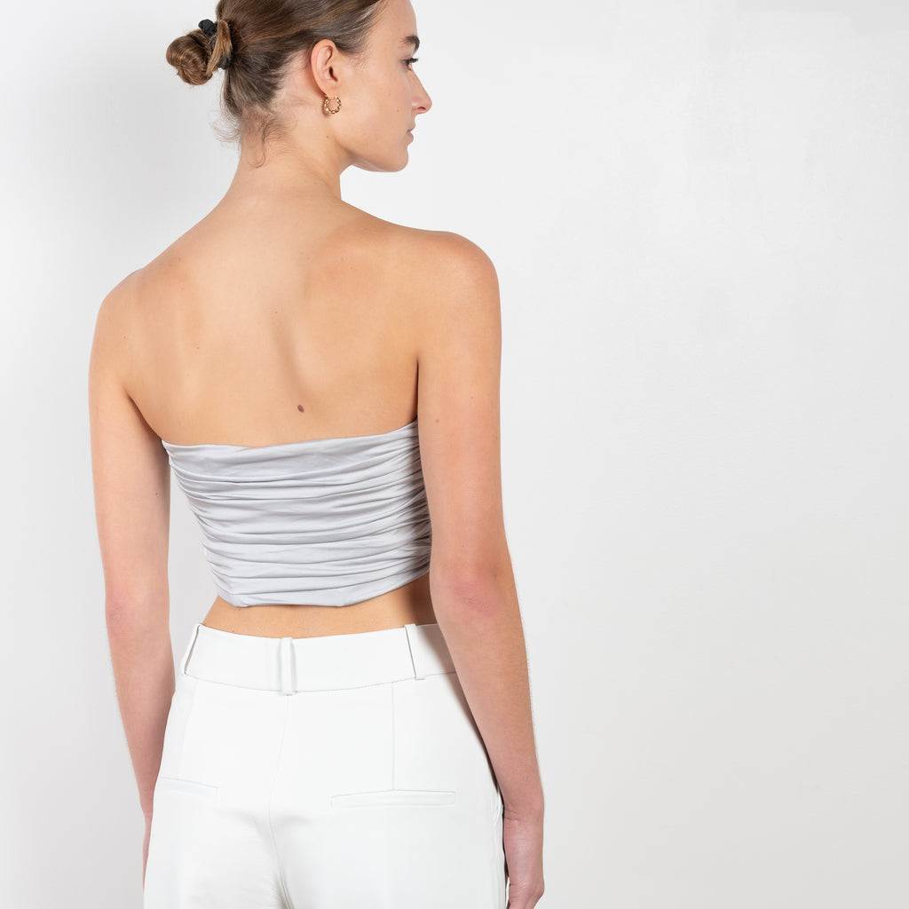 The Sesis Top by GAUGE81 is a minimal bustier top with ruching creating waves and a bold V neck