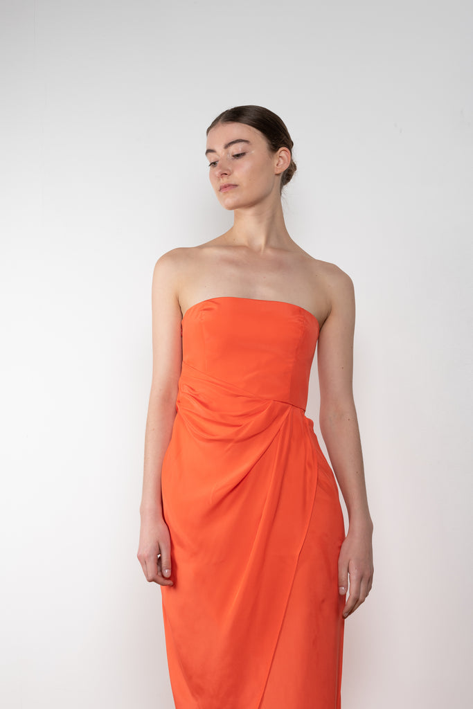 The Lica Long Dress by Gauge81 is a long silk bustier dress with front slit in a vibrant orange linen
