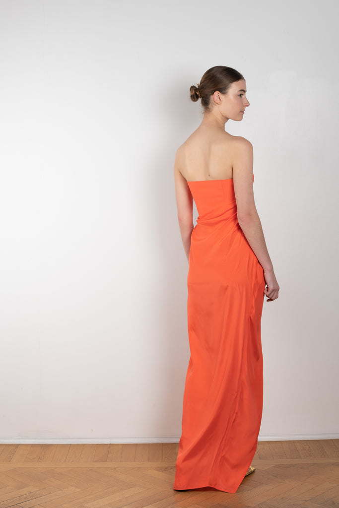 The Lica Long Dress by Gauge81 is a long silk bustier dress with front slit in a vibrant orange linen