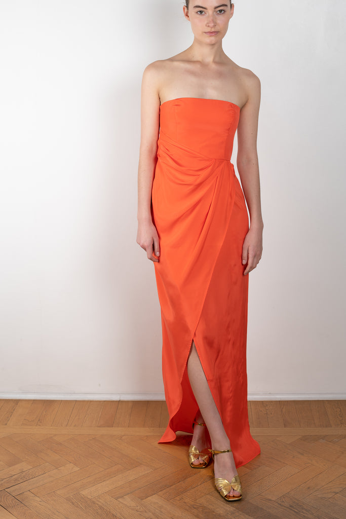 The Lica Long Dress by Gauge81 is a long silk bustier dress with front slit in a vibrant orange linen