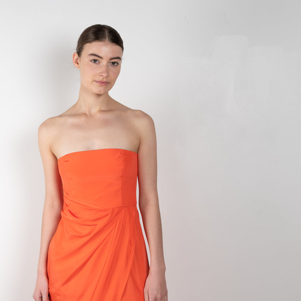 The Lica Long Dress by Gauge81 is a long silk bustier dress with front slit in a vibrant orange linen